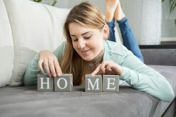 Premium Photo | Portrait of cute woman making word "home" from letters on bricks