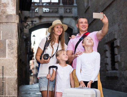 Happy parents with two kids taking selfie near city sights фотография Stock | Adobe Stock