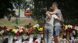 Люди приносять квіти, щоб віддати останню шану жертвам російського ракетного обстрілу в Кременчуці